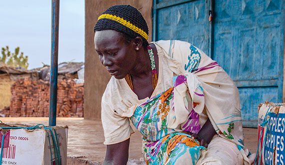 At a village market in South Sudan, a woman sells fruits and vegetables to earn her livelihood.